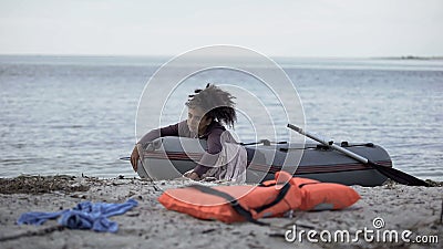 Distressed woman lying in boat waiting help, survived storm, natural disaster Stock Photo