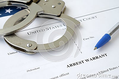 District Court Arrest Warrant court papers with handcuffs and blue pen on United States flag. Concept of permission to arrest Stock Photo