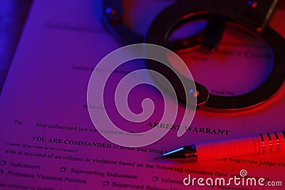 District Court Arrest Warrant court papers with handcuffs and blue pen on United States flag. Concept of permission to Stock Photo