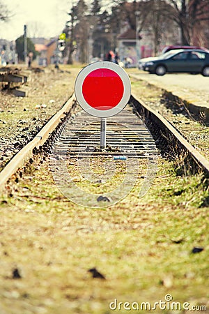 Disused Railroad covered in grass during spring with stop sign blocking access. Stock Photo