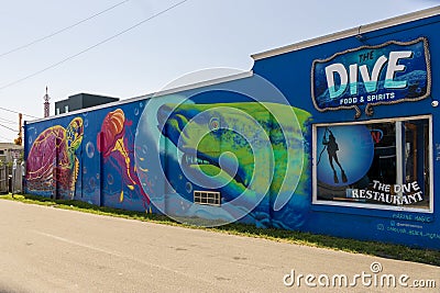The Dive food and spirits restaurant with a beautiful wall mural with a shark, a jellyfish and a turtle and blue sky Editorial Stock Photo