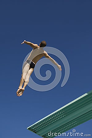 Diver Diving From Springboard In Midair Stock Photo