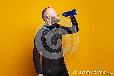 Diver drinking on bright studio wall background Stock Photo