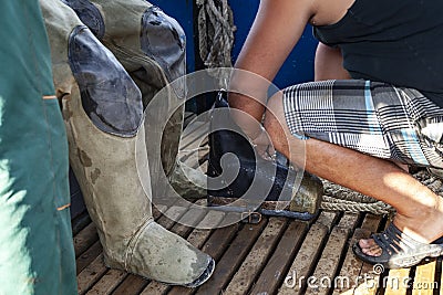 Diver puts on diving galoshes on board a boat Stock Photo