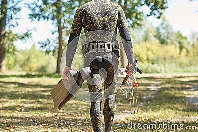 Diver in wet suit and flippers with a harpoon shotgun get ready for water hunting fishing Stock Photo