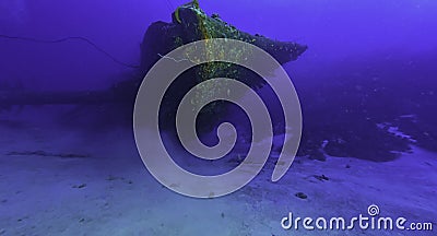 Divers doing a safety stop under the dive boat Stock Photo