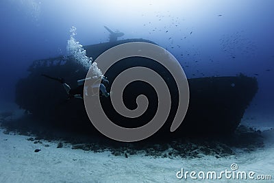 divers enjoying a deep wreck ship Stock Photo