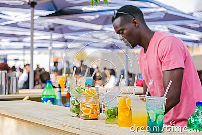 Diverse African vendor serving cocktail drinks at outdoor festival Editorial Stock Photo