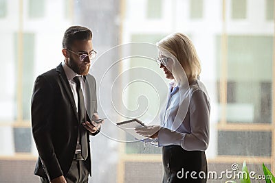 Diverse colleagues met at hallway discuss current business issues Stock Photo