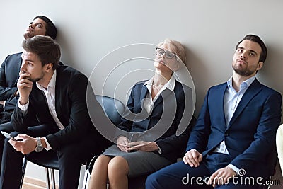 Diverse applicants getting bored in queue waiting for job interview Stock Photo