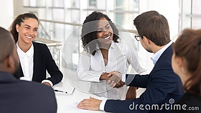 Diverse business partners shaking hands starting collaboration at group negotiations Stock Photo