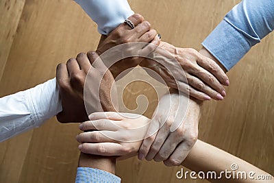 Diverse business people team grasping hands, close up top view Stock Photo