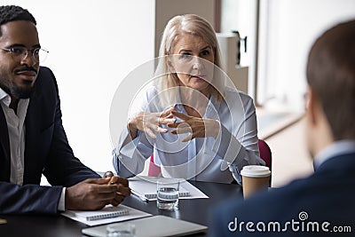 Diverse businesspeople discuss project at meeting together Stock Photo