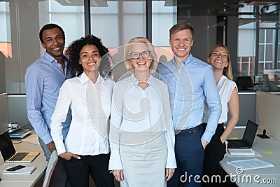 Diverse colleagues led by company chief posing for camera Stock Photo