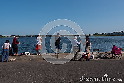 Diverse Collection of People Fishing from a Pier Editorial Stock Photo