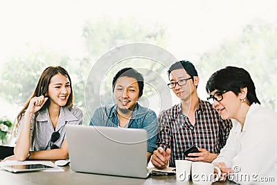 Diverse group of Asian business coworkers or college students using laptop in team casual meeting, startup project discussion Stock Photo