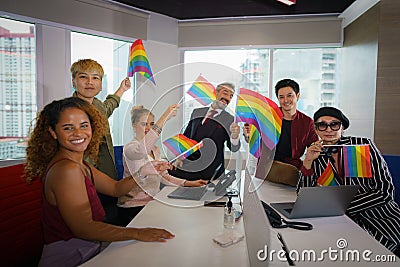 Diverse business people with LGBTQ have rainbow flag on hand Stock Photo