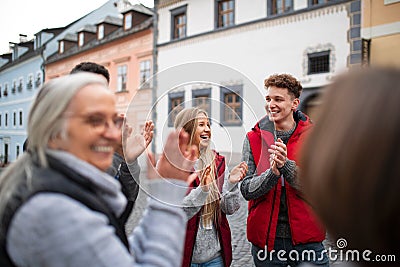 Diverse group of happy community service volunteers claping hands outdoors in street Stock Photo