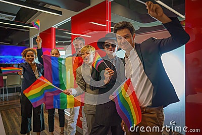 Diverse group of lgbtq people with rainbow flag on hand team up together Stock Photo