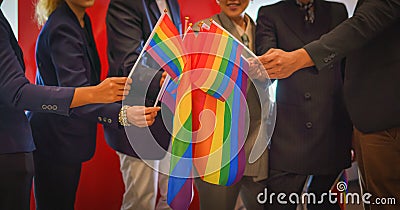 Diverse group of lgbtq people with rainbow flag on hand team up together Stock Photo