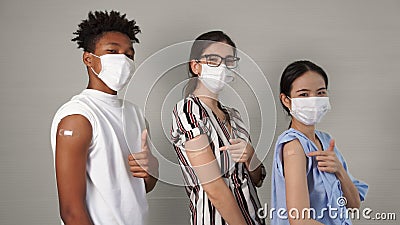 Diverse group of people showing COVID-19 vaccine bandage merrily Stock Photo