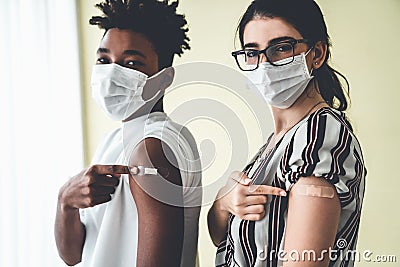 Diverse group of people showing COVID-19 vaccine bandage merrily Stock Photo