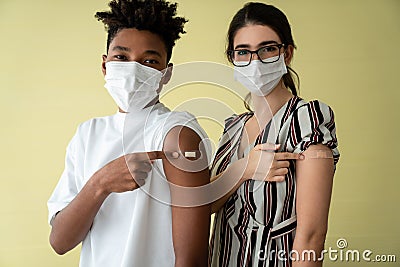 Diverse group of people showing COVID-19 vaccine bandage merrily Stock Photo