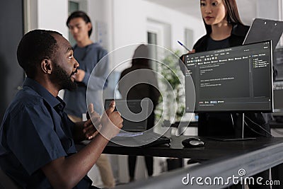 Diverse group of web developers analyzing html code and comparing data script Stock Photo