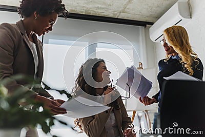 Diverse group of smiling business women having a break in office talking Stock Photo