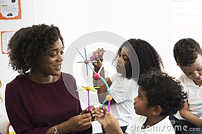 Diverse kindergarten students holding learning structures from t Stock Photo