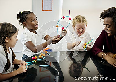 Diverse kindergarten students holding learning structures from t Stock Photo