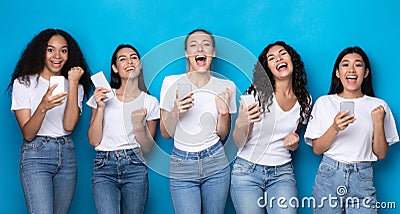 Diverse Ladies Holding Cellphones Gesturing Yes Over Blue Background, Panorama Stock Photo