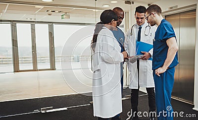 Diverse medical team consulting on a patient Stock Photo