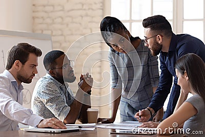 Diverse millennial employees discuss business project at meeting Stock Photo