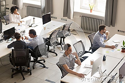 Diverse office workers using computers in modern corporate space Stock Photo