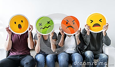 Diverse people holding emoticon icons Stock Photo