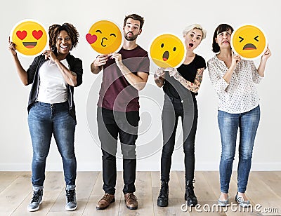 Diverse people holding face emoticon Stock Photo