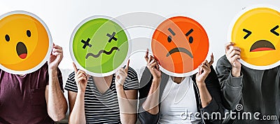 Diverse people holding various emoticons Stock Photo