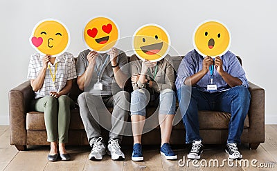 Diverse people sitting and covering face with emojis boards Stock Photo