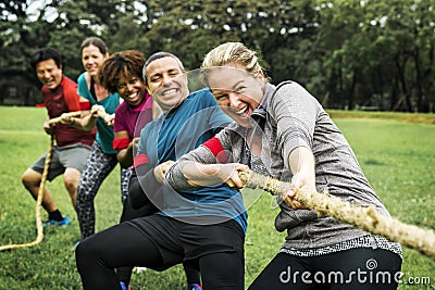 Diverse team competing in tug of war Stock Photo