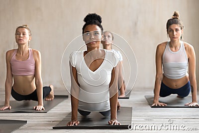 Four attractive diverse women doing upward facing dog pose Stock Photo