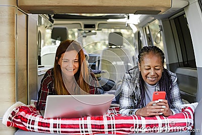 Diverse women working in van during travel Stock Photo