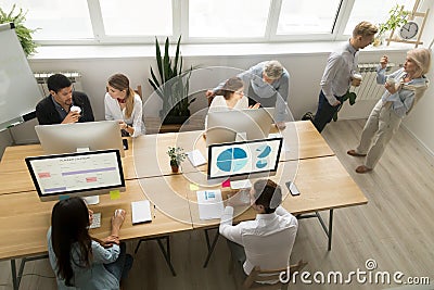 Diverse young and senior office workers collaborating talking, t Stock Photo