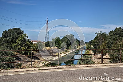 Diversionary channel bordered by trees seen from a bridge on a summer day Stock Photo