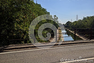 Diversionary channel bordered by trees seen from a bridge Stock Photo