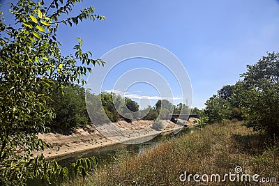 Diversionary channel with trees on a summer day in the italian countryside Stock Photo