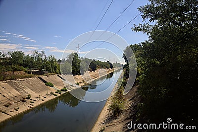Diversionary channel with trees on a summer day in the italian countryside Stock Photo