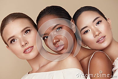 Diversity. Beauty Portrait Of Different Ethnicity Women. Multi-Ethnic Models Standing Together Against Beige Background. Stock Photo