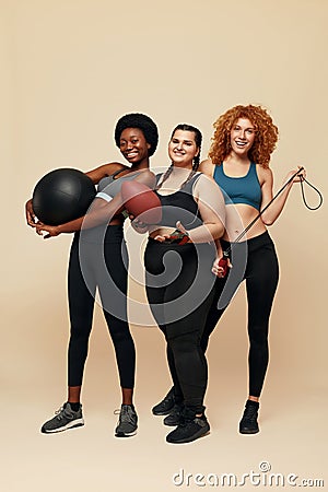 Diversity Models. Different Ethnicity And Size Women. Smiling Multicultural Friends In Sportswear Holding Fitness Equipment. Stock Photo