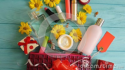 Diversos cosméticos decorativos del envase del bolso del maquillaje cosmético de la piel en las flores de madera azules, perfumes almacen de video Diversos cosméticos decorativos del envase del bolso del maquillaje cosmético de la piel en las flores de madera azules, perfumes almacen de video